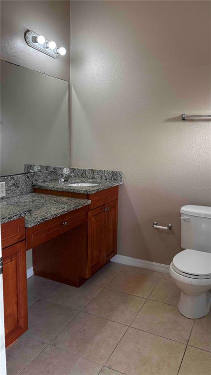 9410 Citrus Glen Place Tampa, FL 33618 - Photo 14 of 30 a bathroom with a granite countertop sink a toilet and a mirror