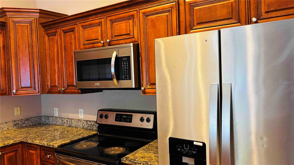 9410 Citrus Glen Place Tampa, FL 33618 - Photo 27 of 30 a kitchen with stainless steel appliances granite countertop a refrigerator and a stove top oven