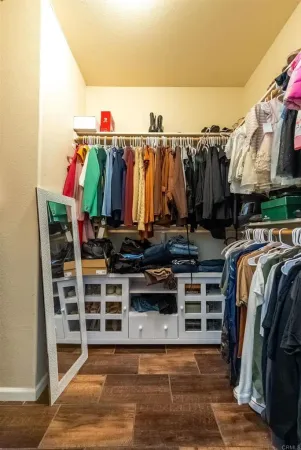 a view of walk in closet with clothes and shoes
