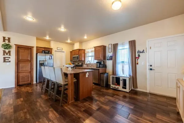 a kitchen with stainless steel appliances a refrigerator and wooden floor