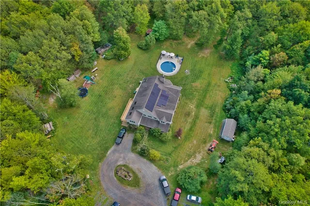 an aerial view of a house with a yard and swimming pool