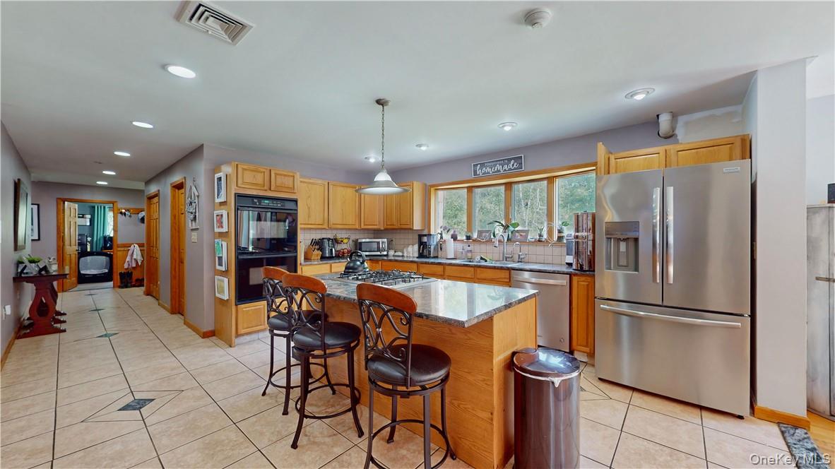 75 Monahan Road Port Jervis, NY 12771 - Photo 17 of 36 a kitchen with stainless steel appliances granite countertop a refrigerator a sink dishwasher a dining table and chairs with wooden floor