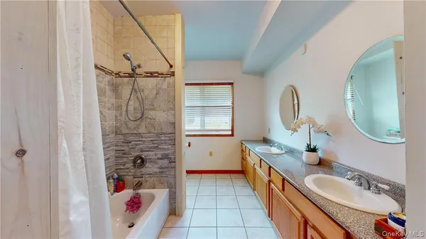 a bathroom with a granite countertop sink mirror and bathtub