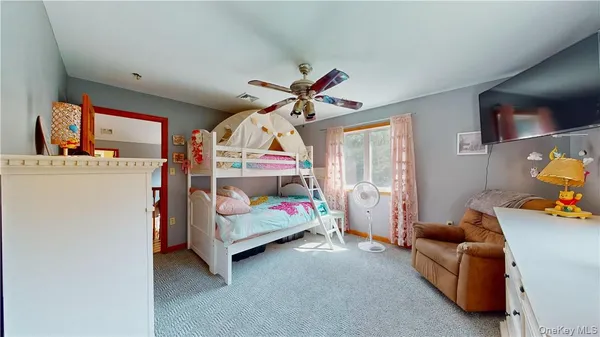 a bedroom with furniture and a chandelier fan
