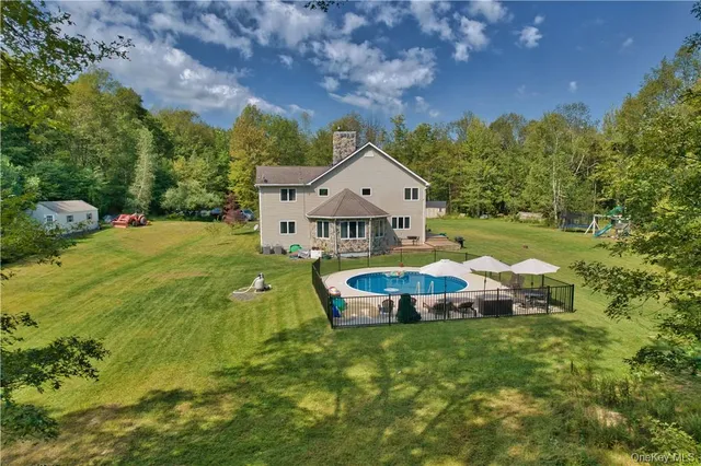 a aerial view of a house with a big yard and large trees