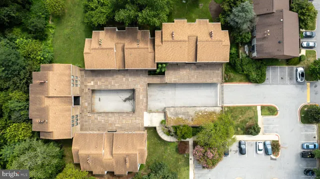 an aerial view of residential house with outdoor space and trees all around