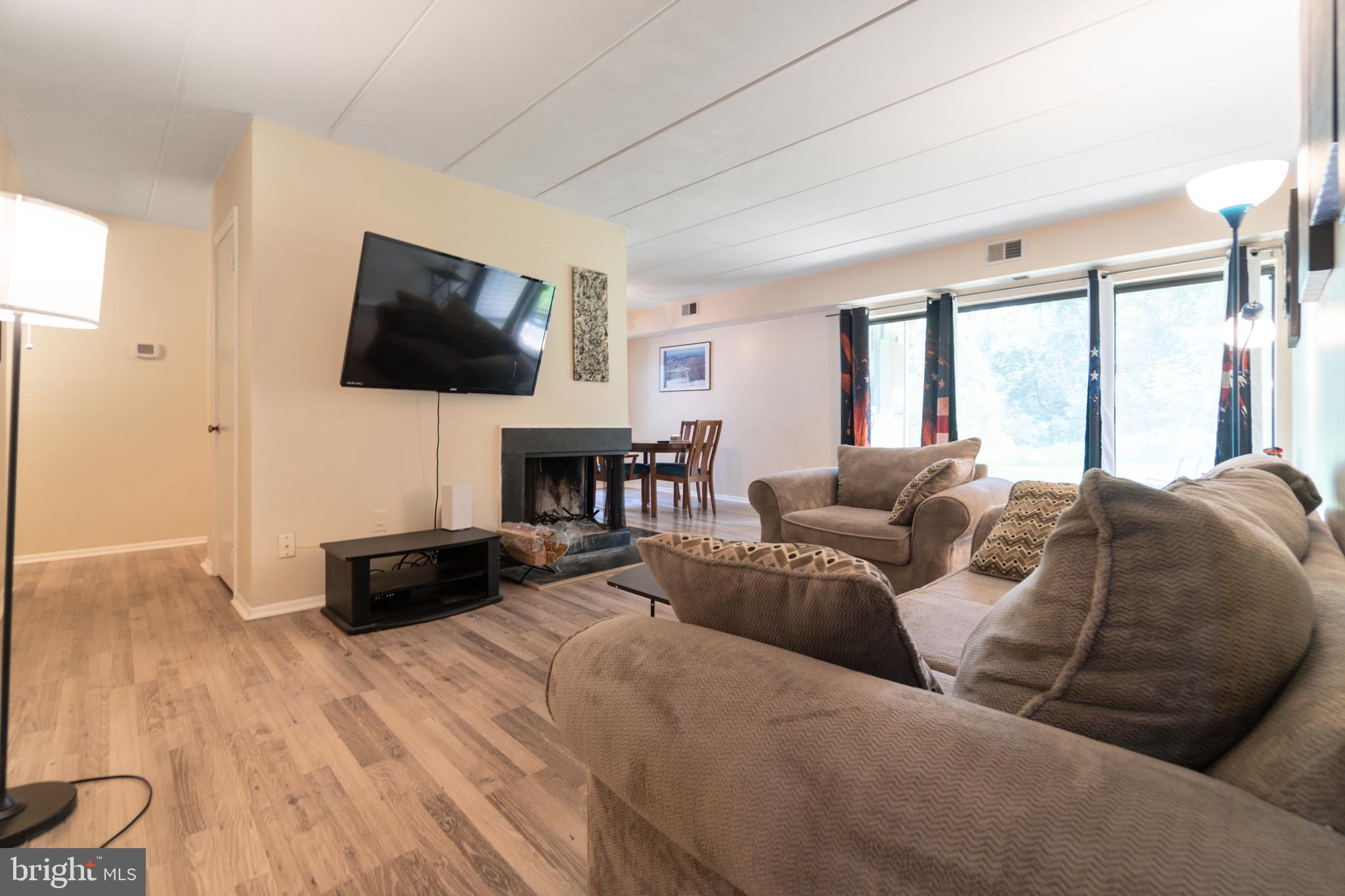 5390 Smooth Meadow Way, Unit B2D02 Columbia, MD 21044 - Photo 3 of 28 a living room with furniture a flat screen tv and a large window
