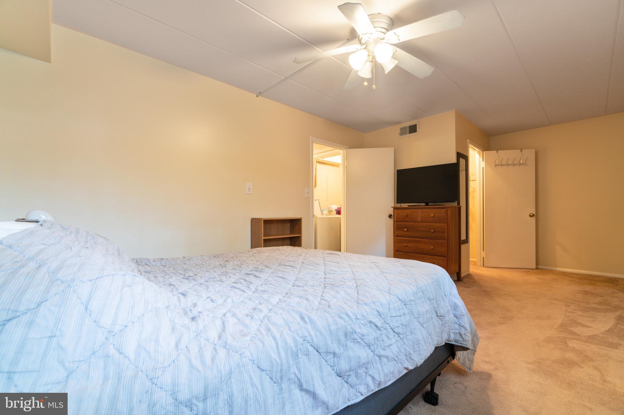 5390 Smooth Meadow Way, Unit B2D02 Columbia, MD 21044 - Photo 9 of 28 a spacious bedroom with a bed and a flat screen tv