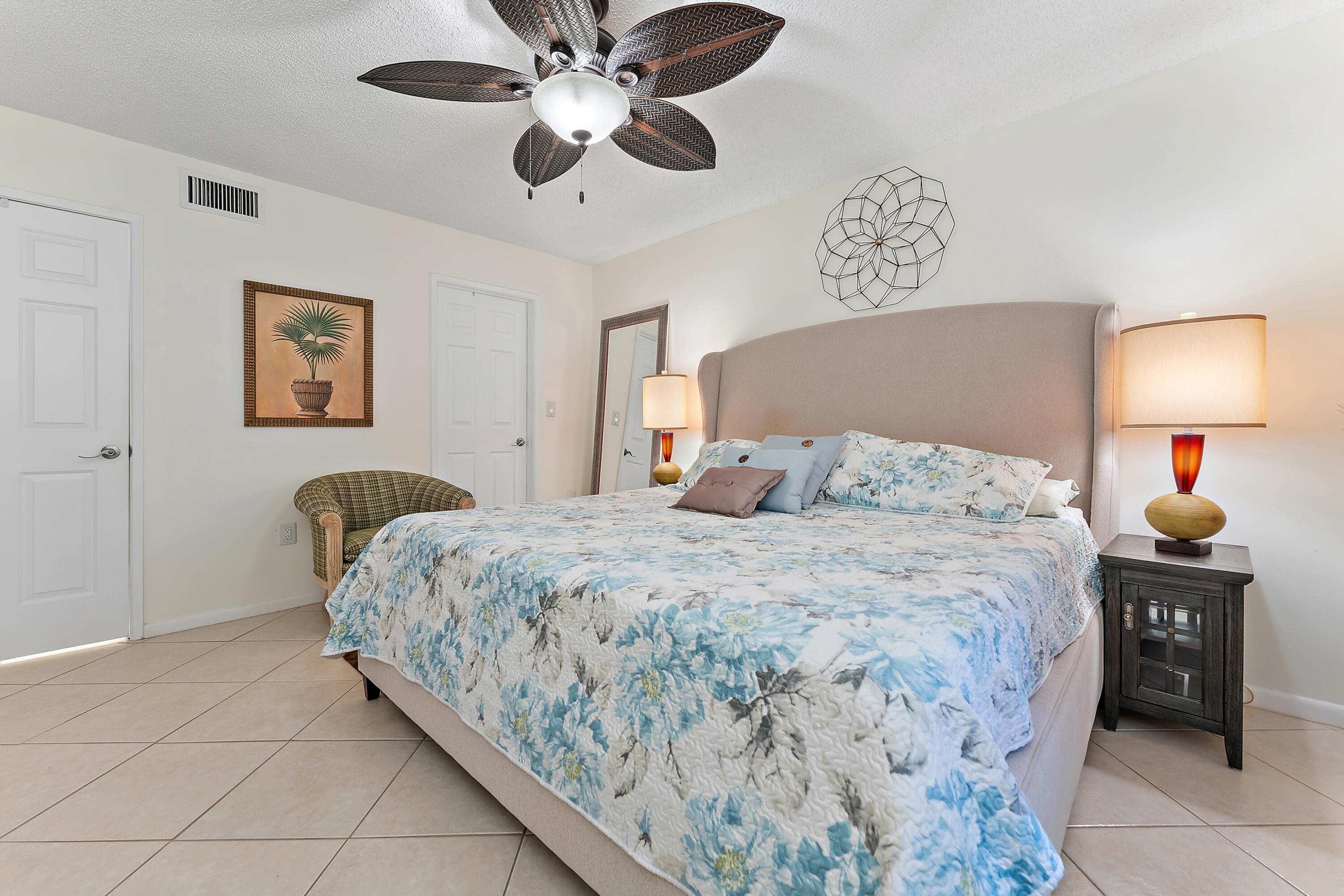 275 Palm Avenue, Unit C503 Jupiter, FL 33477 - Photo 8 of 10 a bedroom with a bed and a lamp on dresser