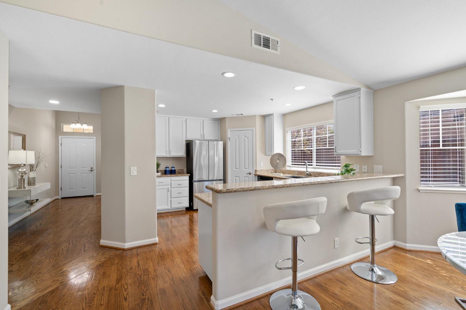 1363 Rincon Avenue Livermore, CA 94551 - Photo 13 of 65 a kitchen with stainless steel appliances granite countertop a kitchen island a stove a refrigerator a sink and a dining table with wooden floor