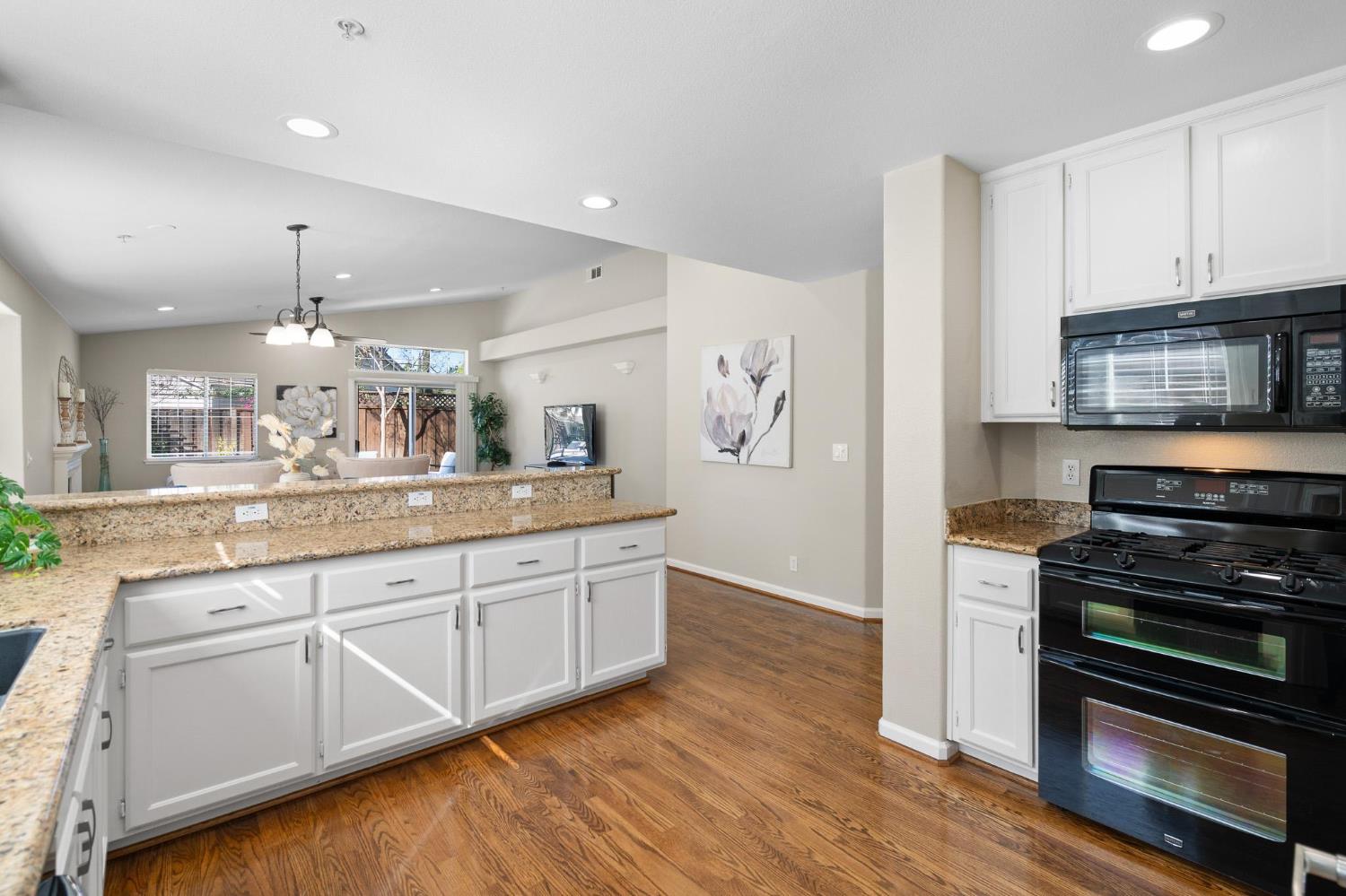 1363 Rincon Avenue Livermore, CA 94551 - Photo 16 of 65 a large kitchen with cabinets wooden floor and stainless steel appliances