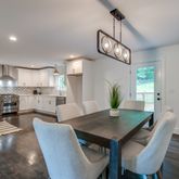 a view of a dining room and a kitchen with a table chairs