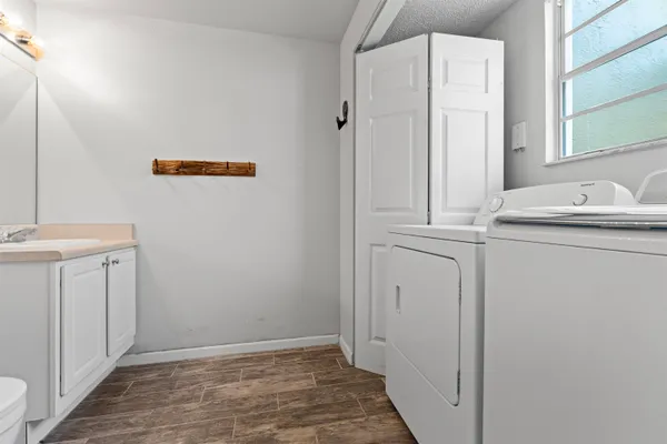 a view of a bathroom with mirror and washer