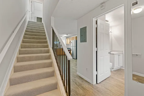 a view of a hallway with wooden floor and entryway