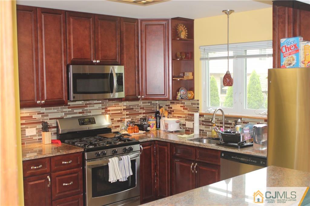 7 Lydia Lane Edison, NJ 08817 - Photo 11 of 17 a kitchen with stainless steel appliances wooden cabinets and a stove top oven
