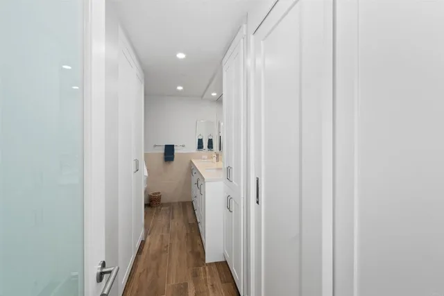 a view of a hallway with wooden floor and staircase