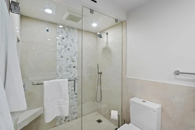 a bathroom with a shower a toilet and sink