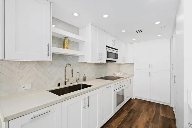 a kitchen with white cabinets stainless steel appliances and sink