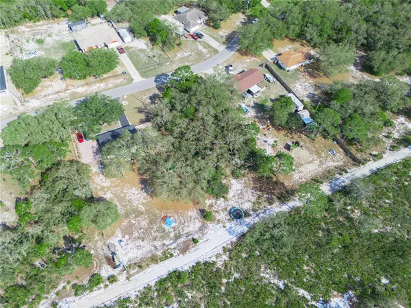 an aerial view of residential house with outdoor space and trees all around