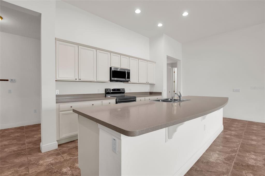 531 Villa Park Road Kissimmee, FL 34759 - Photo 5 of 63 a kitchen with a sink a microwave and cabinets