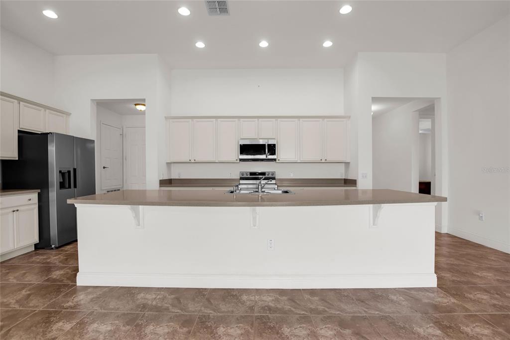 531 Villa Park Road Kissimmee, FL 34759 - Photo 6 of 63 a large kitchen with stainless steel appliances a large counter top a stove and a refrigerator