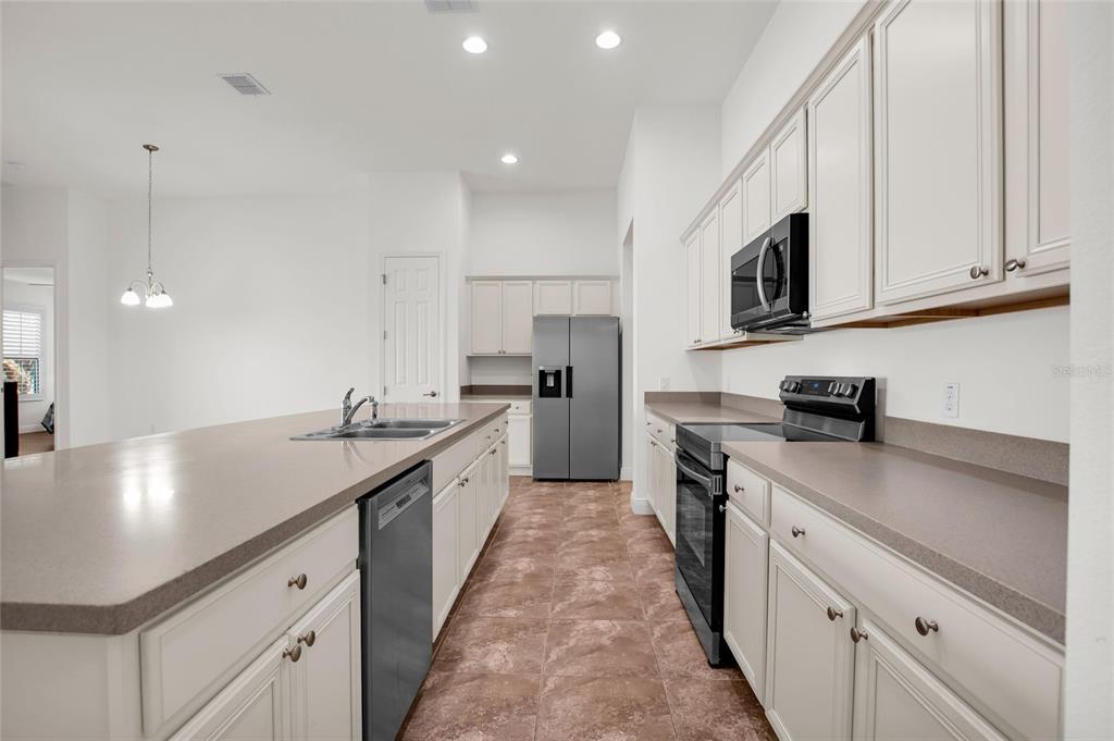 531 Villa Park Road Kissimmee, FL 34759 - Photo 8 of 63 a kitchen with stainless steel appliances granite countertop a sink stove and refrigerator