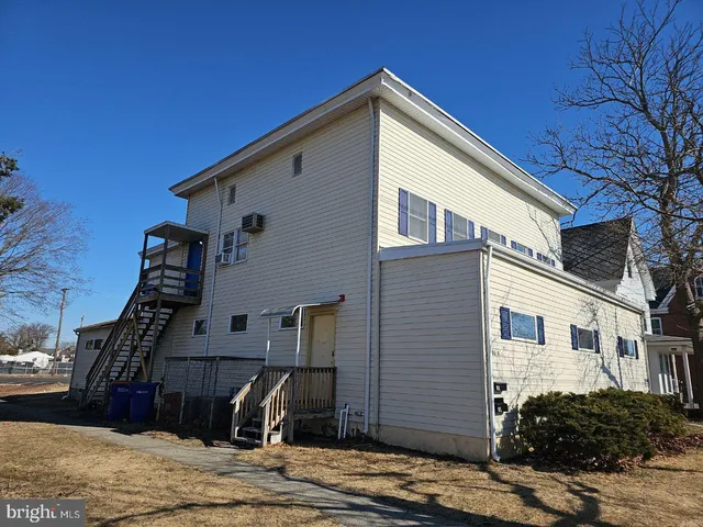 a view of a house with a small yard and wooden fence
