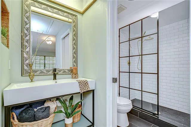 a bathroom with a sink a toilet and a mirror