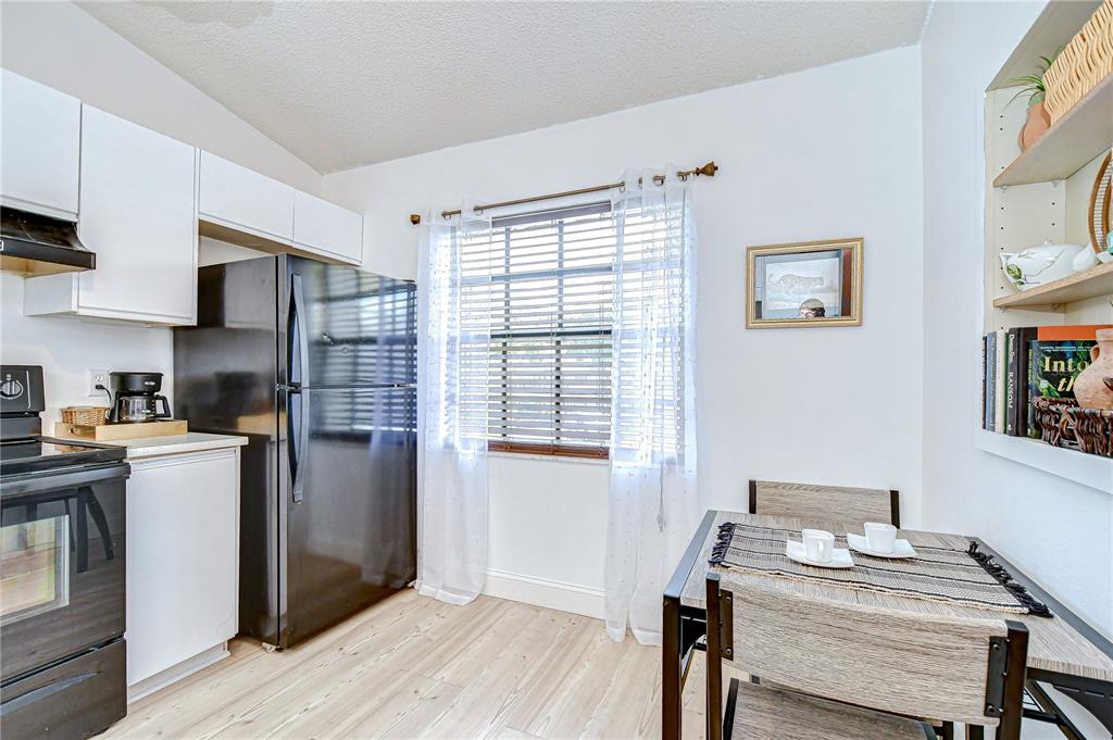 2139 Elm Street, Unit 308 Dunedin, FL 34698 - Photo 10 of 46 a kitchen with stainless steel appliances wooden floor and a refrigerator