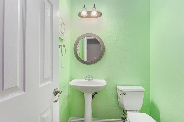 a bathroom with a toilet sink and mirror