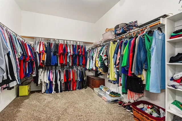 a view of walk in closet with clothes