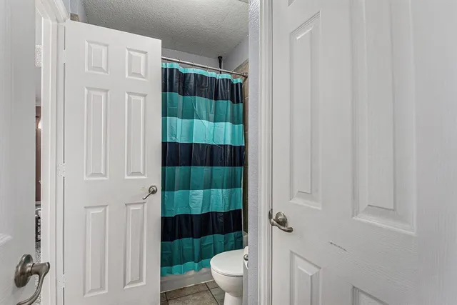 a bathroom with a toilet and a shower