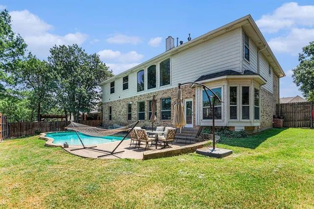 a view of a house with backyard sitting area and swimming pool