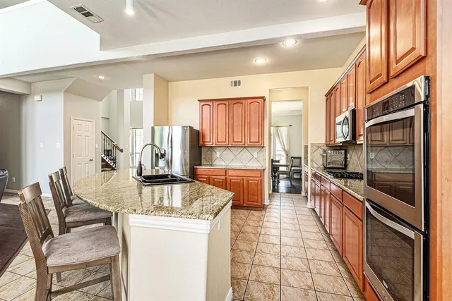 a large kitchen with stainless steel appliances granite countertop a stove and a sink