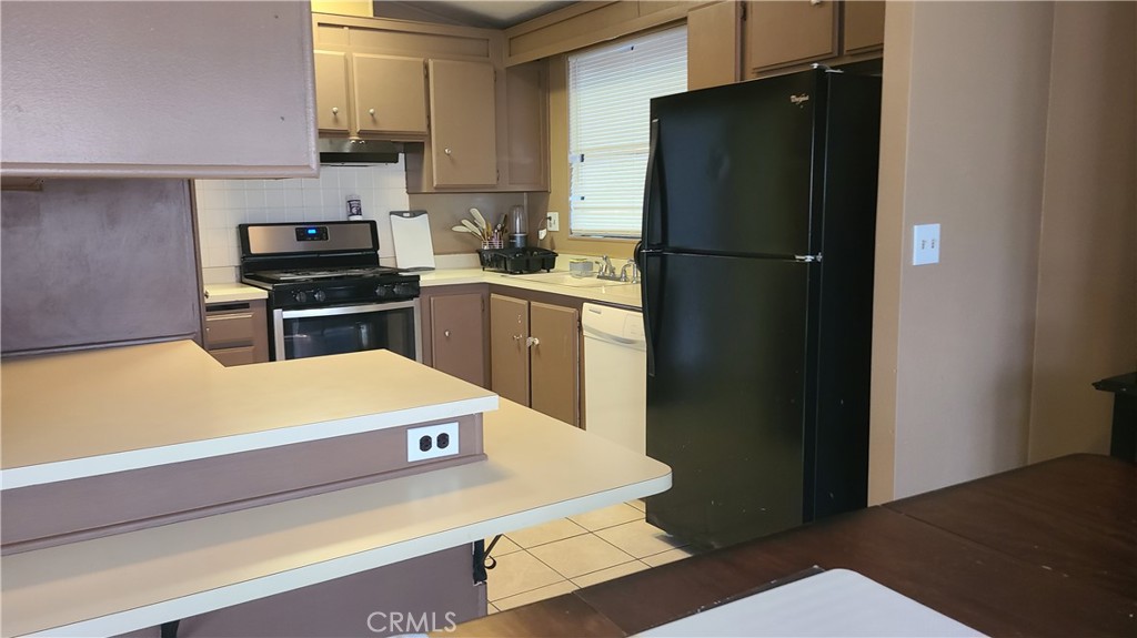 4080 Pedley Road, Unit 49 Jurupa Valley, CA 92509 - Photo 3 of 15 a kitchen with a refrigerator and a stove top oven