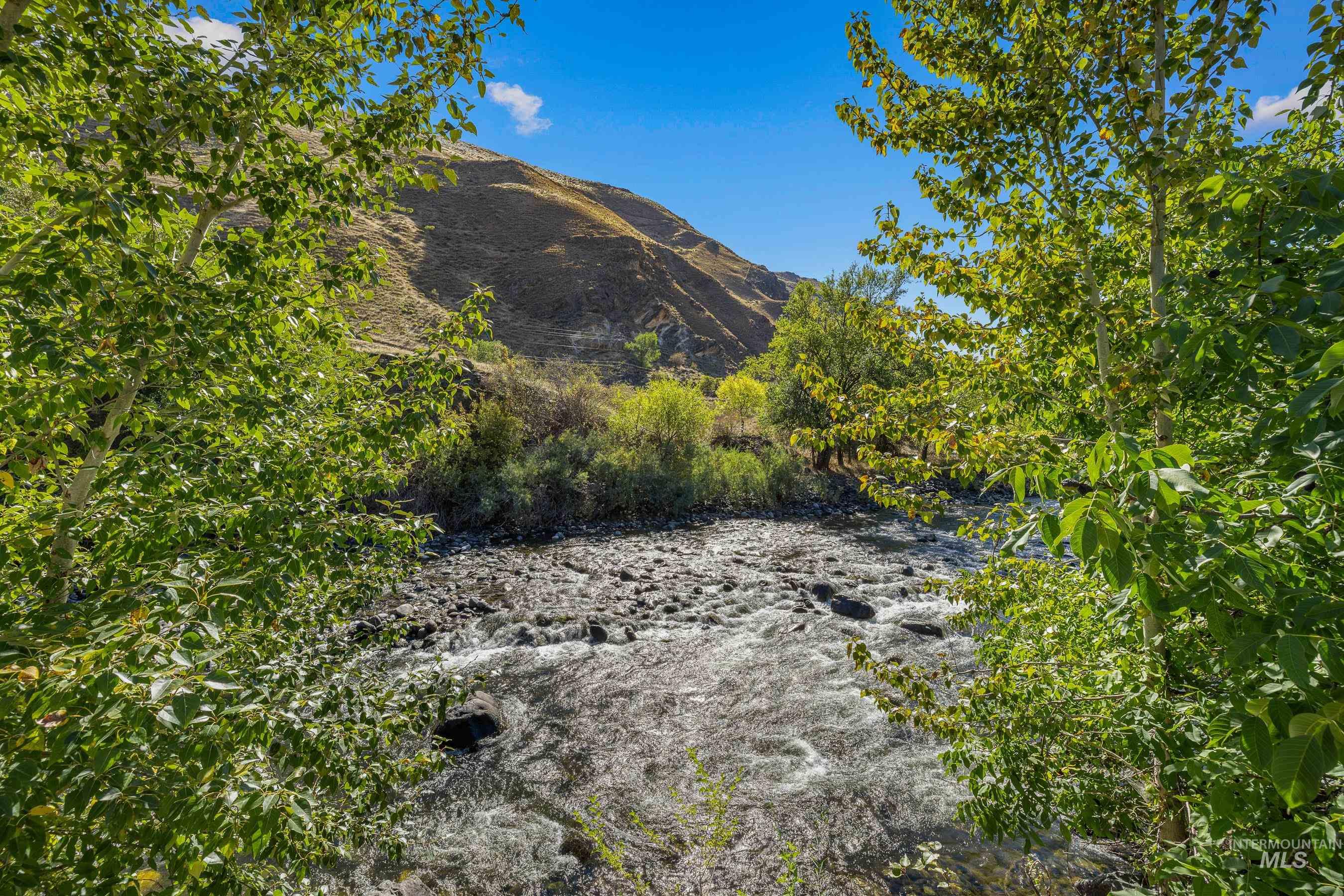 7026 S Highway Riggins, ID 83549 - Photo 47 of 50 Clear water with visible riverbed, natural rock formations, and a tree-lined bank
