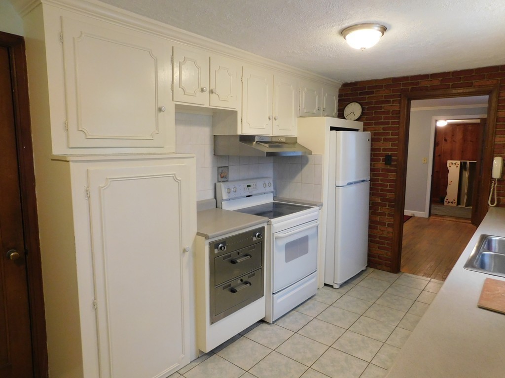 672 Amostown Road West Springfield, MA 01089 - Photo 9 of 30 a kitchen with white cabinets and white appliances