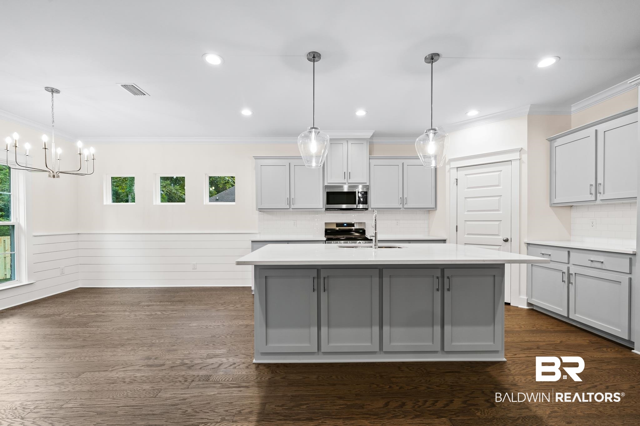 29 Signal Hill Road Daphne, AL 36527 - Photo 10 of 36 Kitchen featuring gray cabinets, dark hardwood / wood-style flooring, decorative light fixtures, and stainless steel appliances