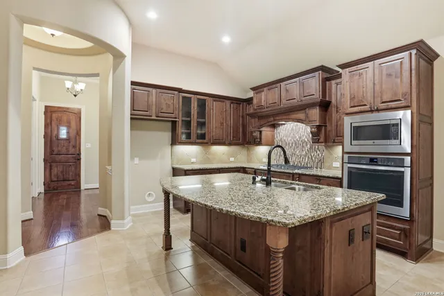 a kitchen with granite countertop a stove and refrigerator