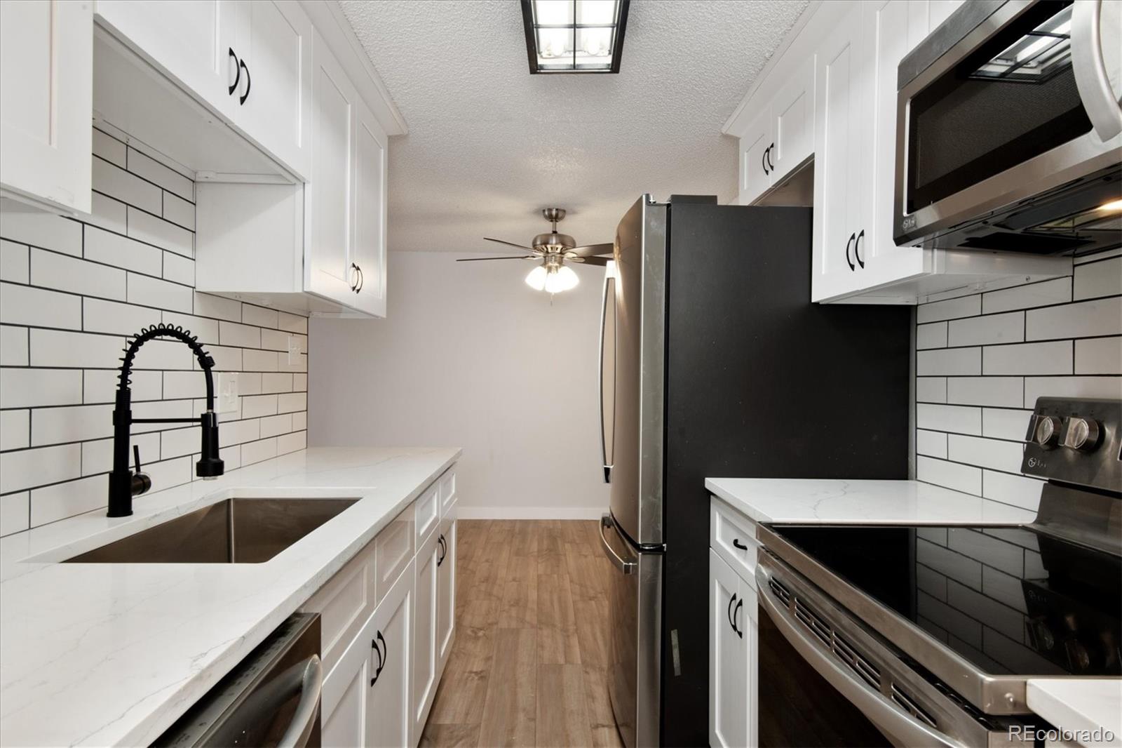 a kitchen with stainless steel appliances kitchen island a refrigerator sink and microwave