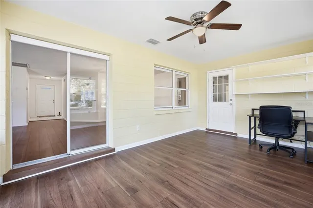 a view of room with hardwood floor and a ceiling fan