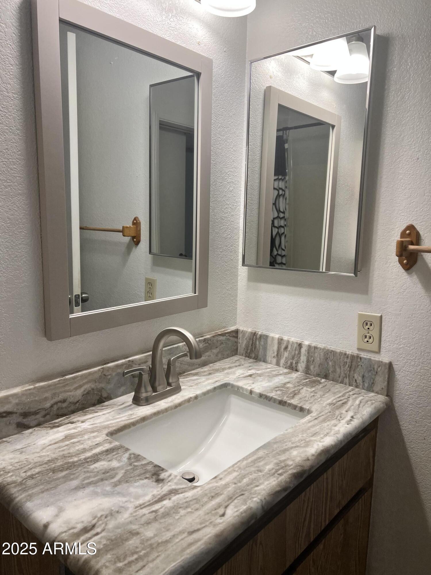 99 North Cooper Road, Unit 136 Chandler, AZ 85225 - Photo 9 of 14 a bathroom with double sink and a mirror