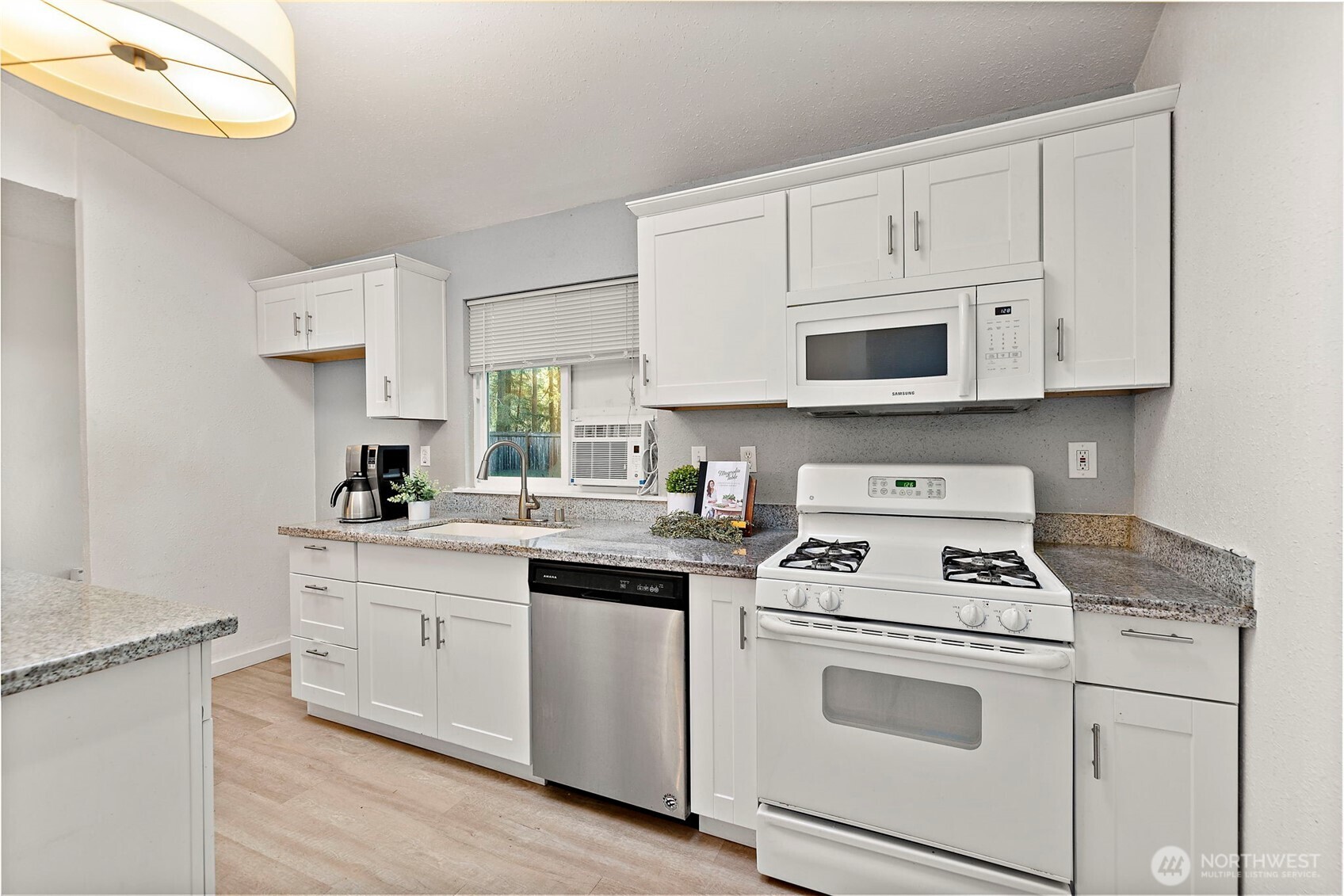19401 Southeast 267th Street Covington, WA 98042 - Photo 7 of 31 a kitchen with cabinets appliances a sink and a counter top space