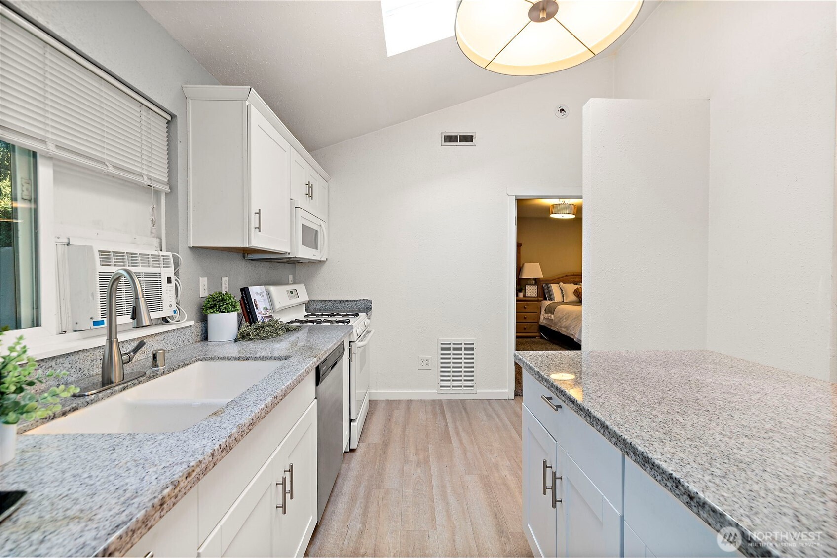 19401 Southeast 267th Street Covington, WA 98042 - Photo 8 of 31 a kitchen with granite countertop a sink a stove and cabinets