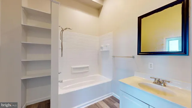 a bathroom with a bathtub sink and mirror