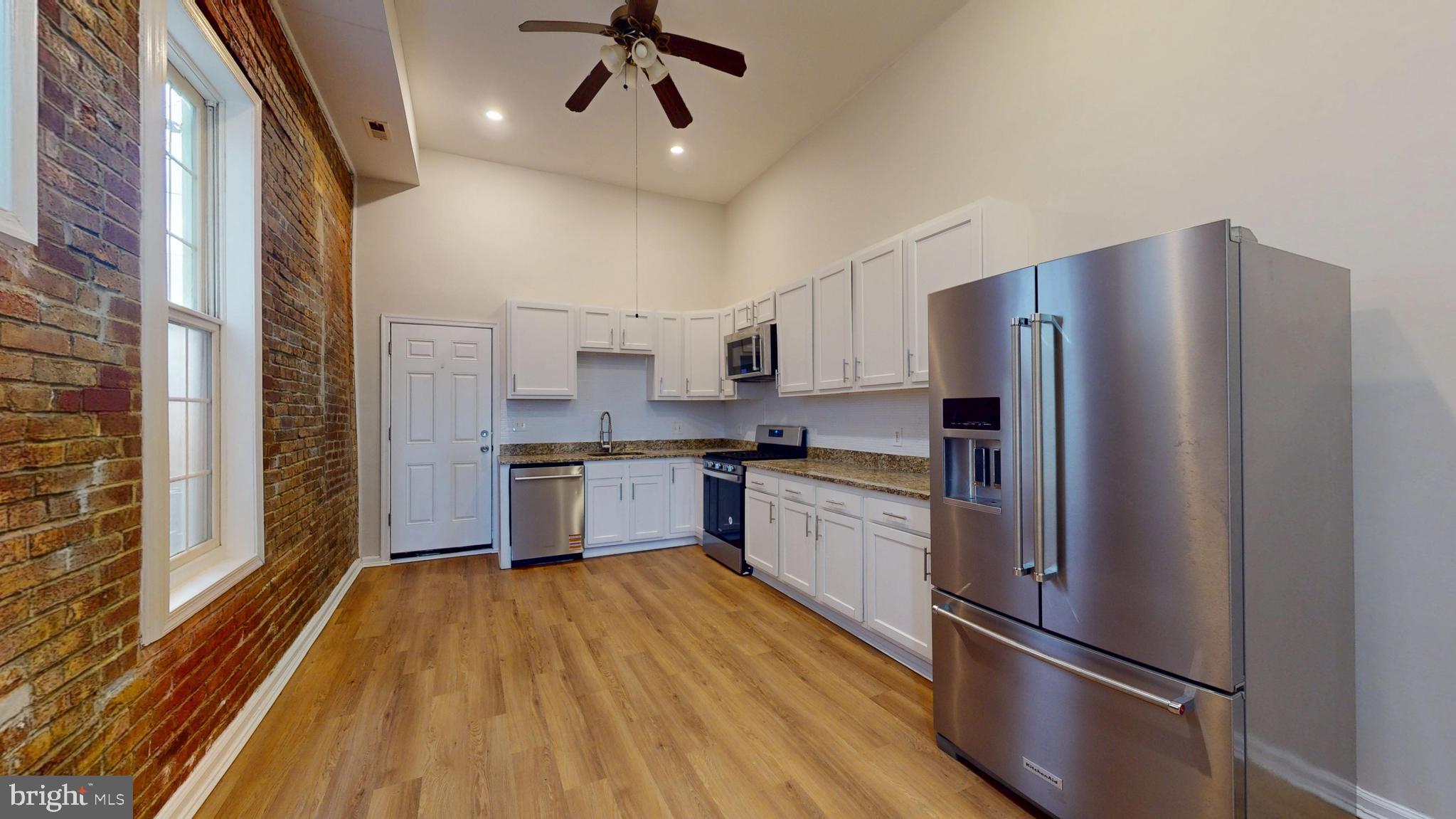 708 North Gilmor Street Baltimore, MD 21217 - Photo 2 of 35 a kitchen with stainless steel appliances a refrigerator and a stove top oven