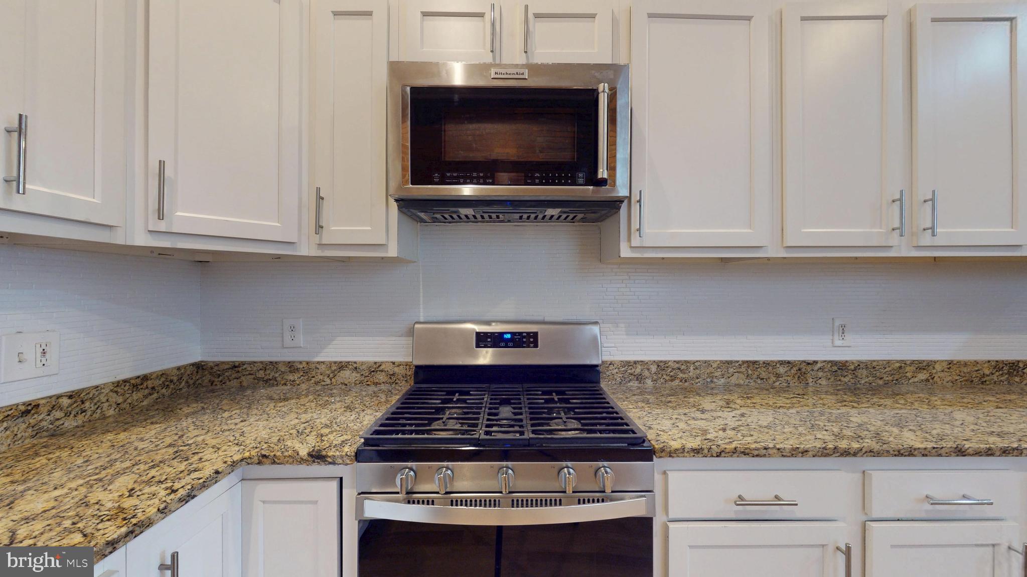 708 North Gilmor Street Baltimore, MD 21217 - Photo 3 of 35 a kitchen with granite countertop a stove and a white cabinets