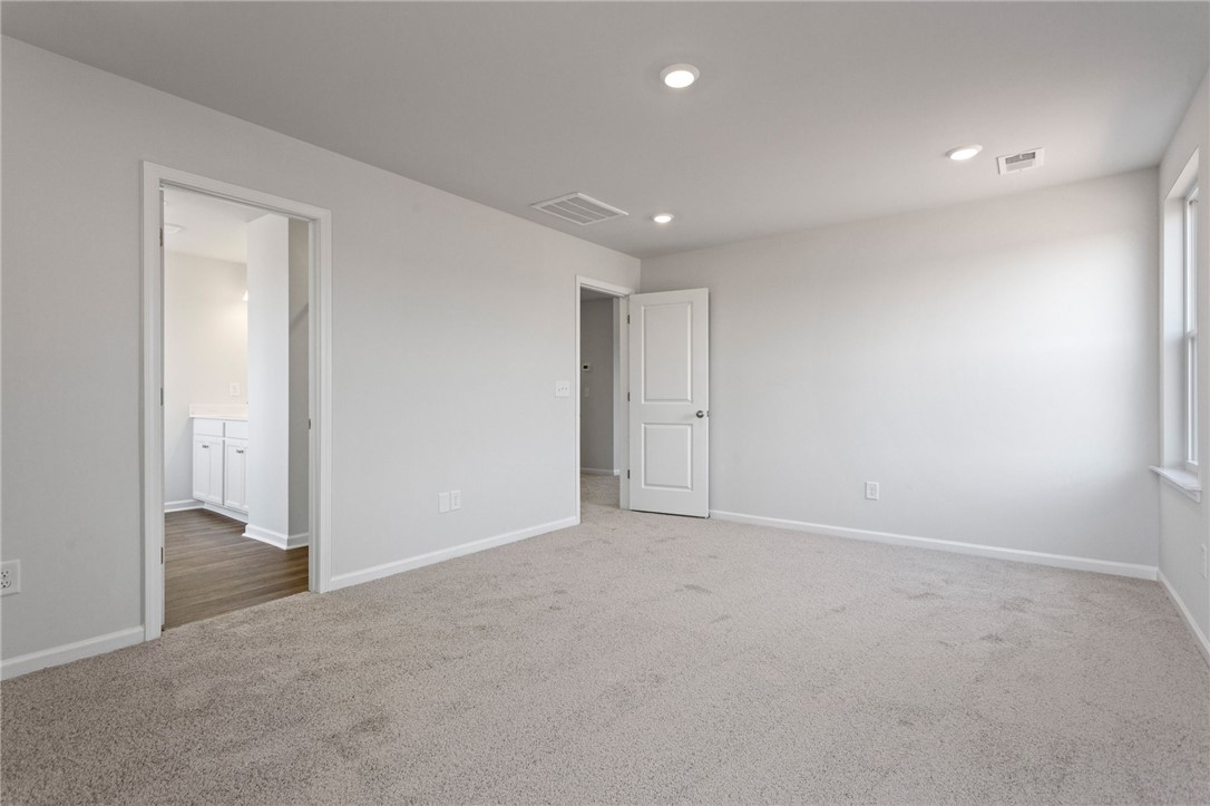135 Cedar Shoals Easley, SC 29640 - Photo 21 of 37 This spacious bedroom offers ample natural light and a clean, neutral palette.
