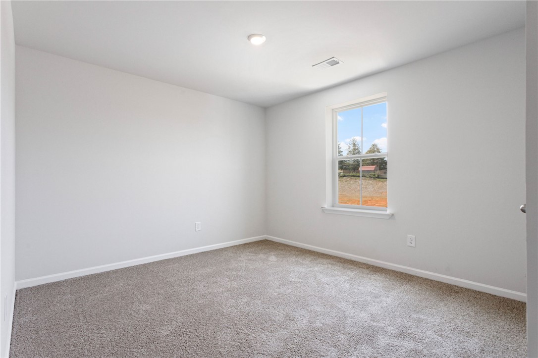 135 Cedar Shoals Easley, SC 29640 - Photo 26 of 37 This spacious room offers comfort and versatility, featuring ample light and plush carpeting.