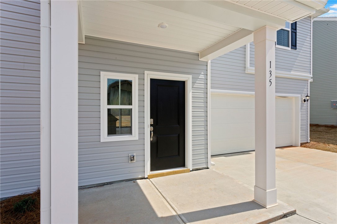 135 Cedar Shoals Easley, SC 29640 - Photo 3 of 37 This inviting home features a covered porch, a durable concrete walkway, and an attached garage.
